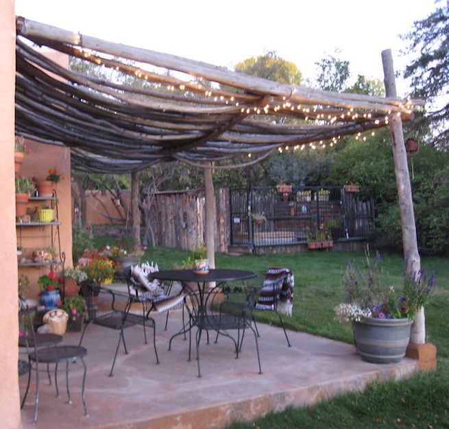 Hinterhofterrasse mit Pergola und Metalltisch und Stühlen