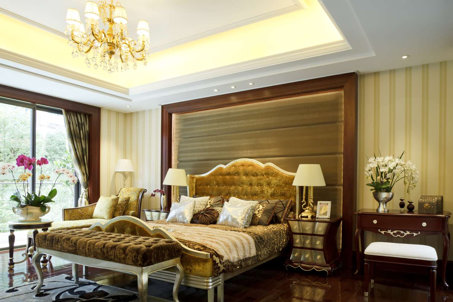 Einzelne Frisurendecke im goldenen Schlafzimmer mit Bett, Beistelltischen, Lampen und Fußbett.
