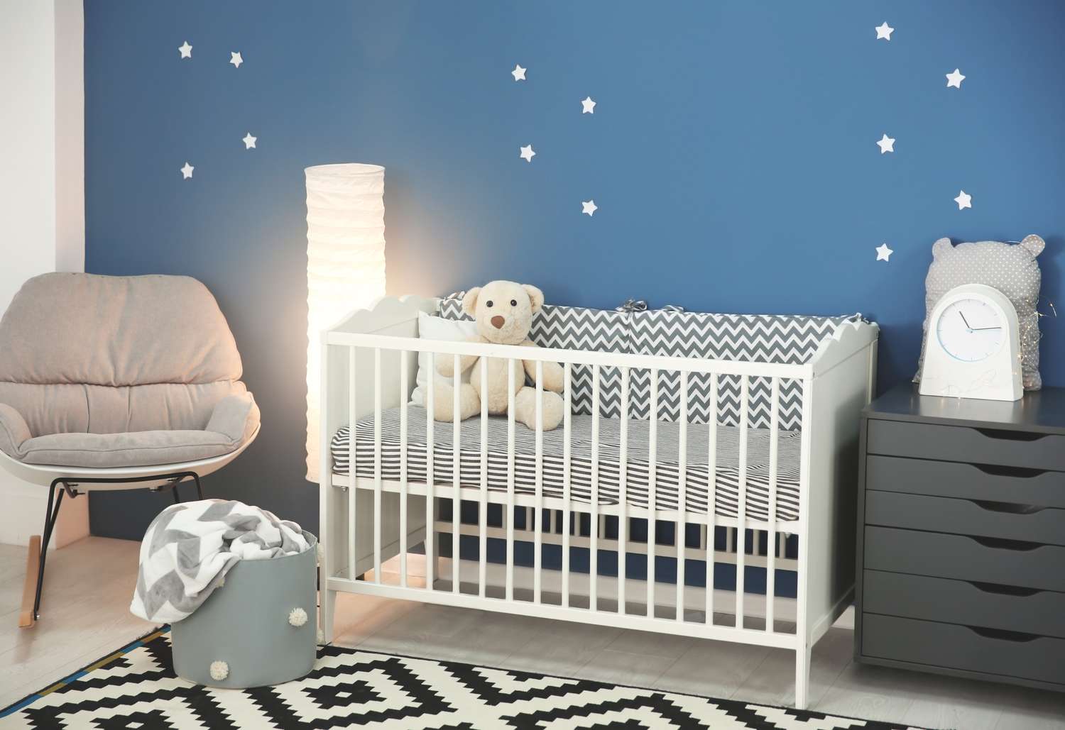 Interior de habitación de bebé con cómoda cuna y mecedora