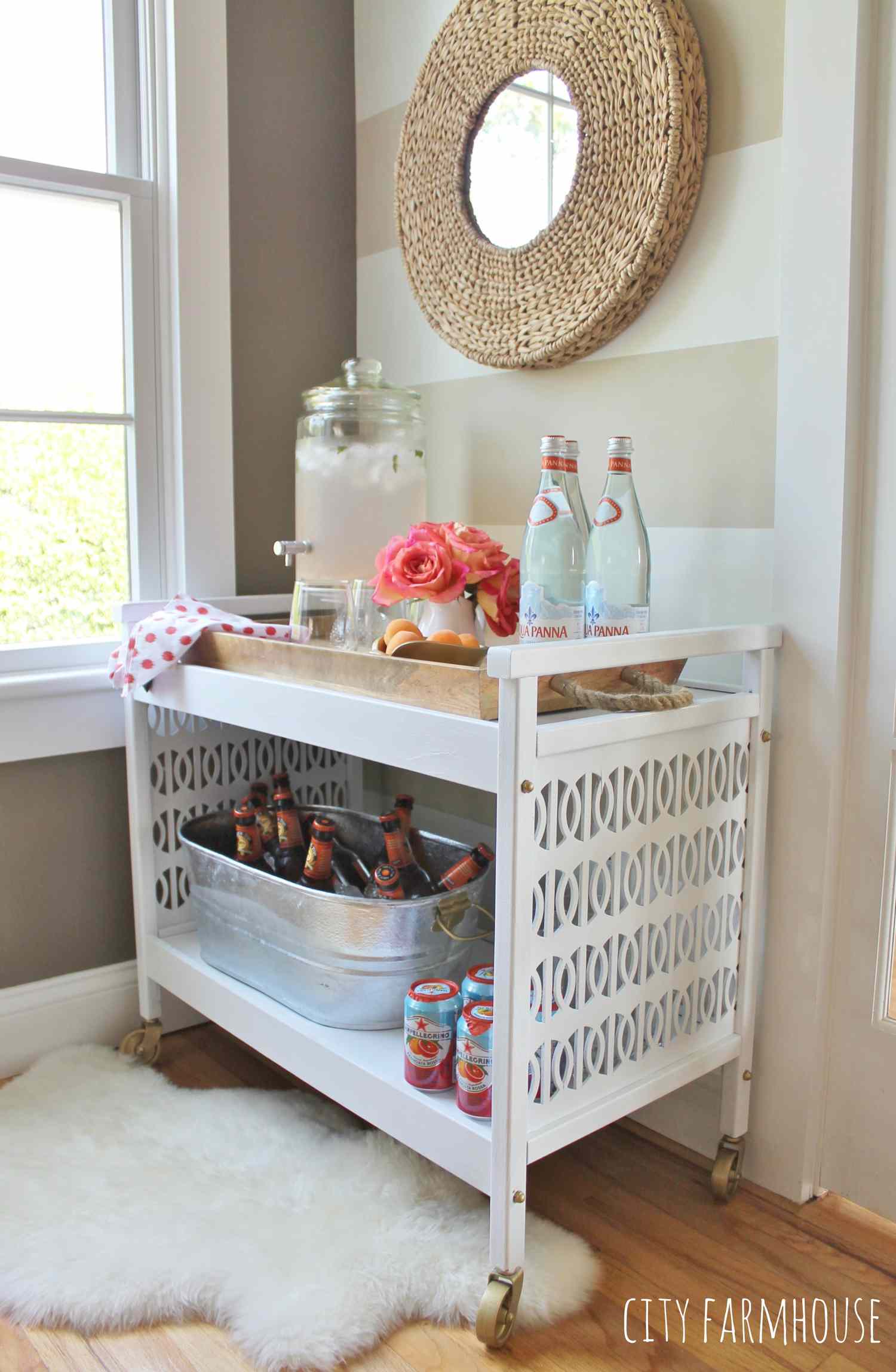 White TV cart displaying a beverage dispenser and a tub of bottles