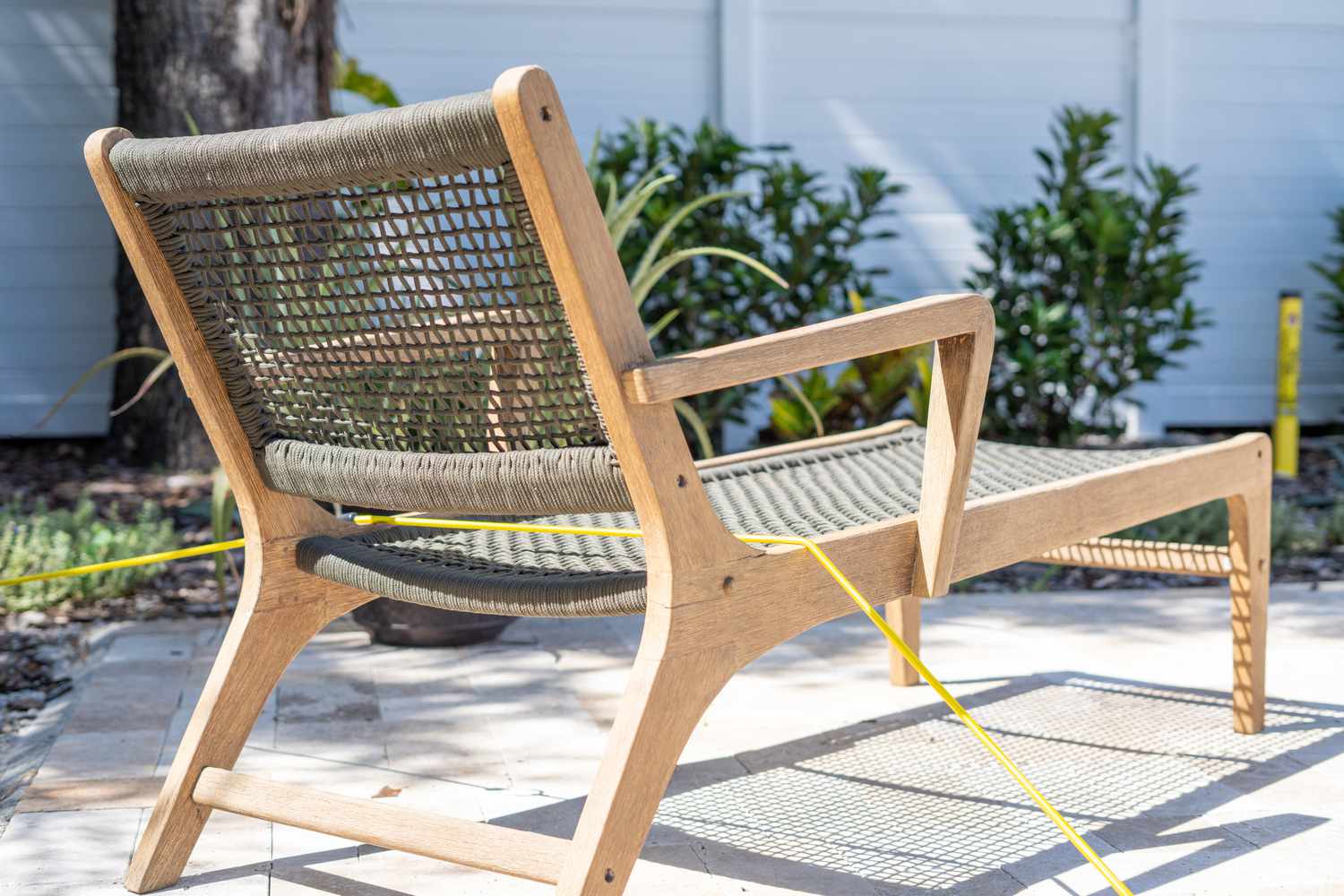 Muebles de piscina asegurados con cuerda amarilla para protegerlos de las tormentas