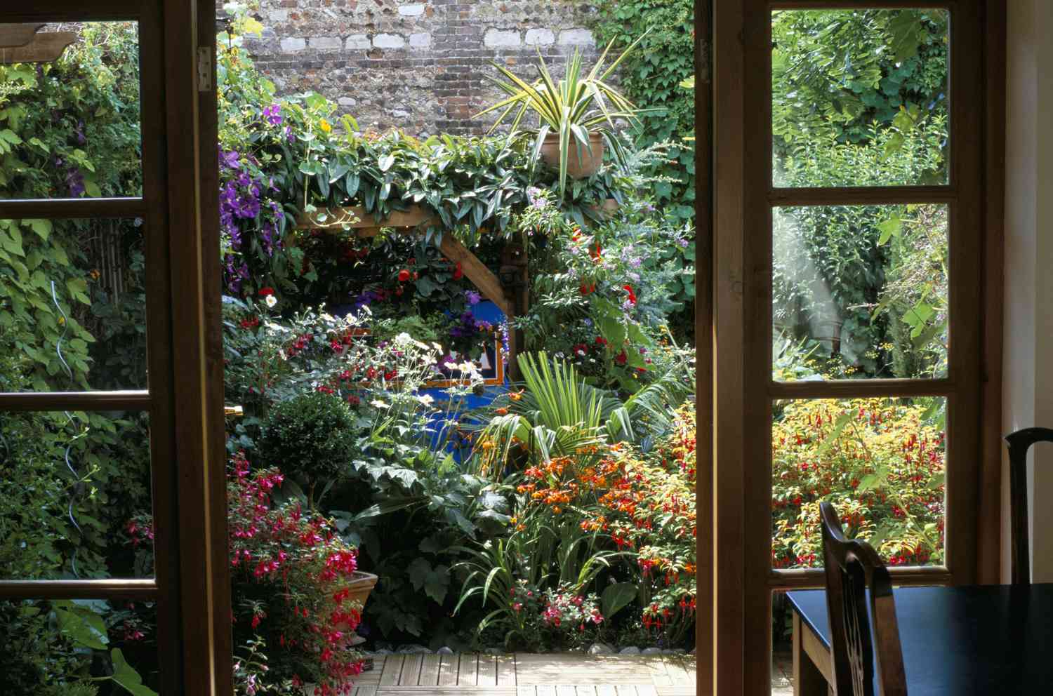 Blick durch Fenstertüren in den kleinen Hofgarten