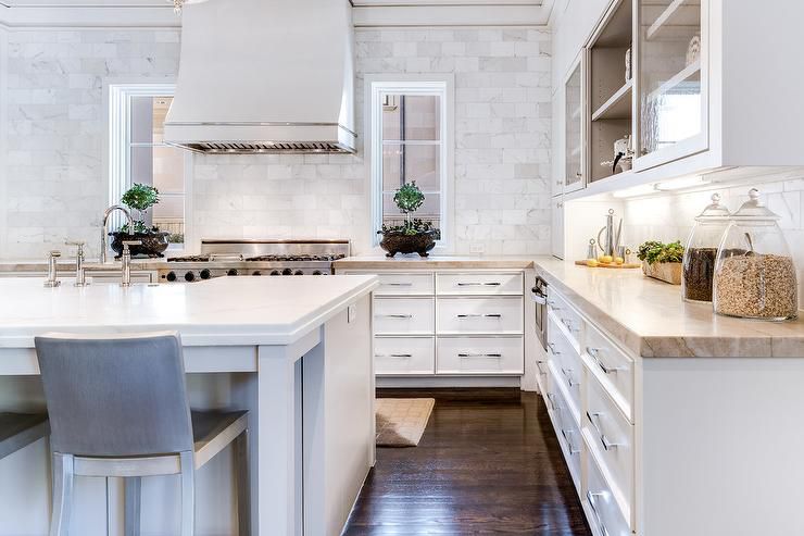 Backsplash de mármore do balcão ao teto em uma cozinha branca