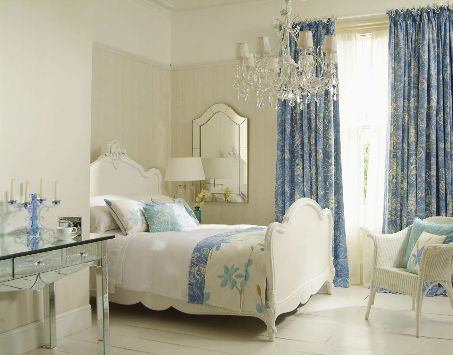 glamorous bedroom with blue floral drapes and white furniture with cream and blue accents