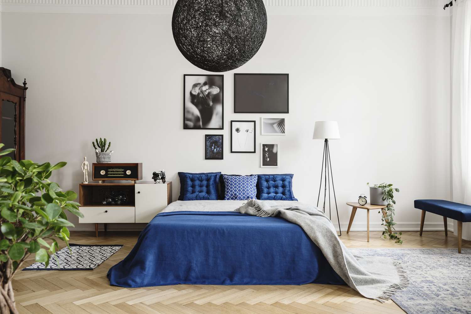 Schwarzer Kronleuchter in einem blau-weißen Schlafzimmer