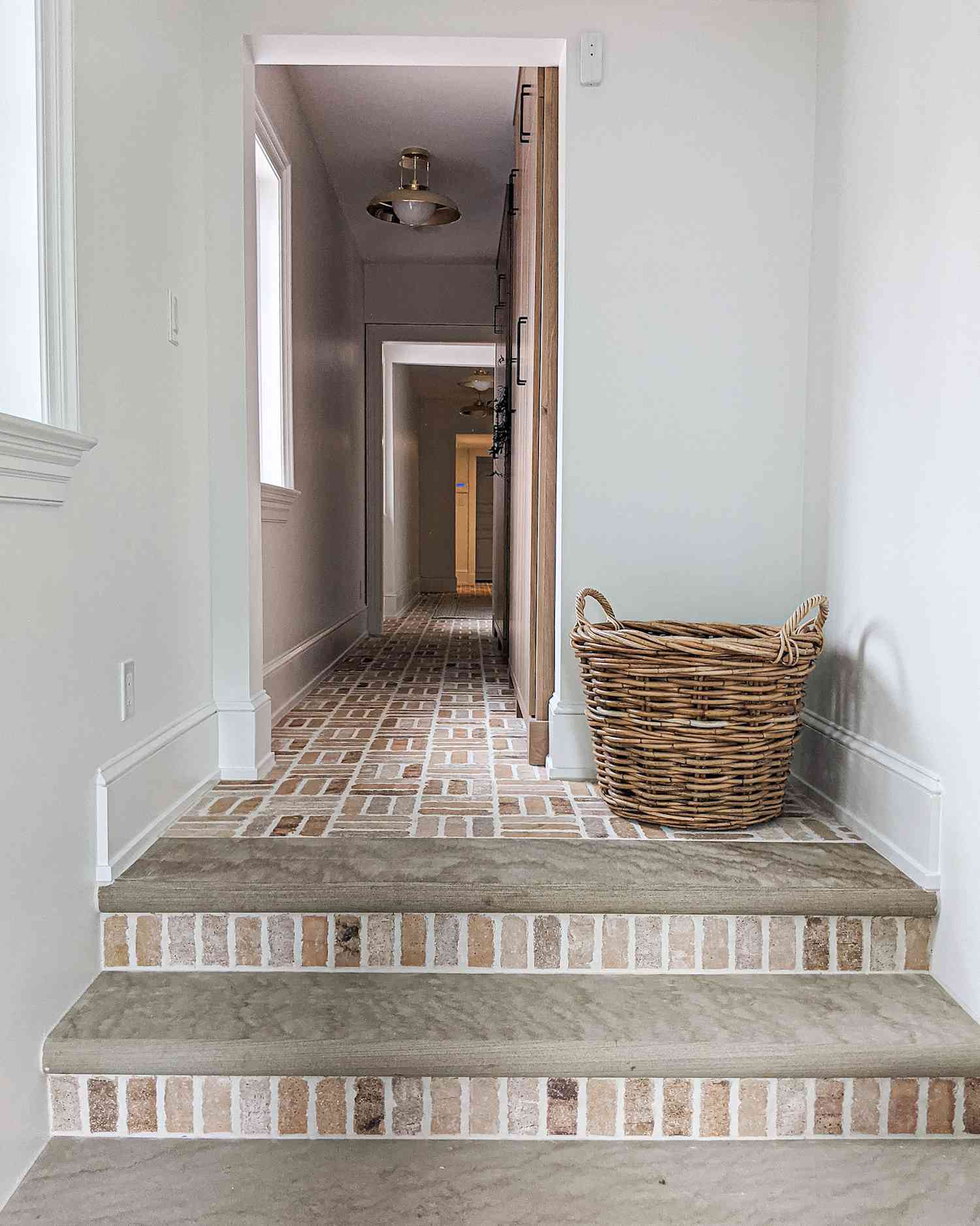 escada de tijolos com uma cesta de vime em um corredor