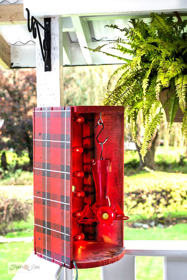 Un calentador alimentador de colibríes rojos