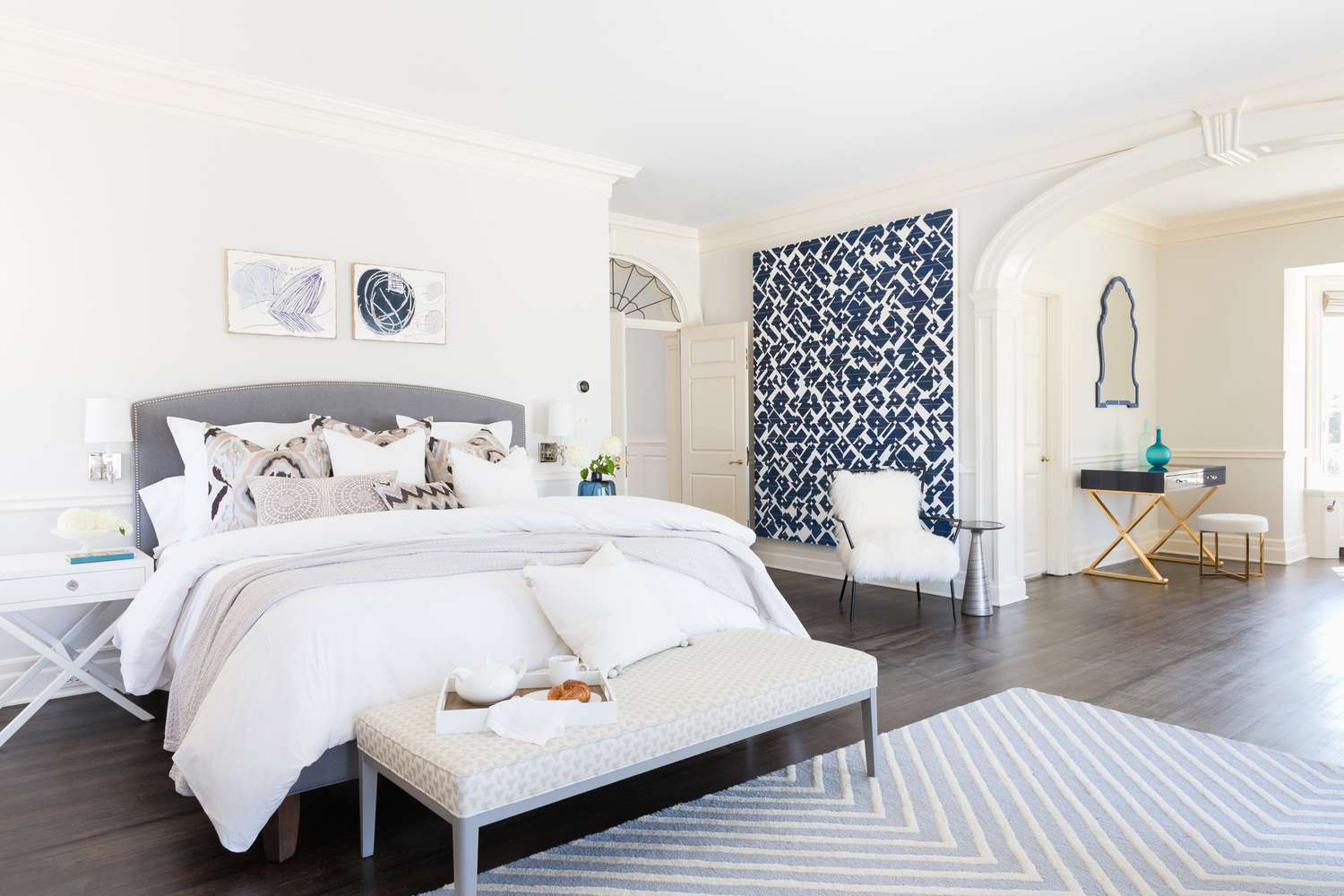 Precioso dormitorio blanco con una pared de acento azul marino y blanco
