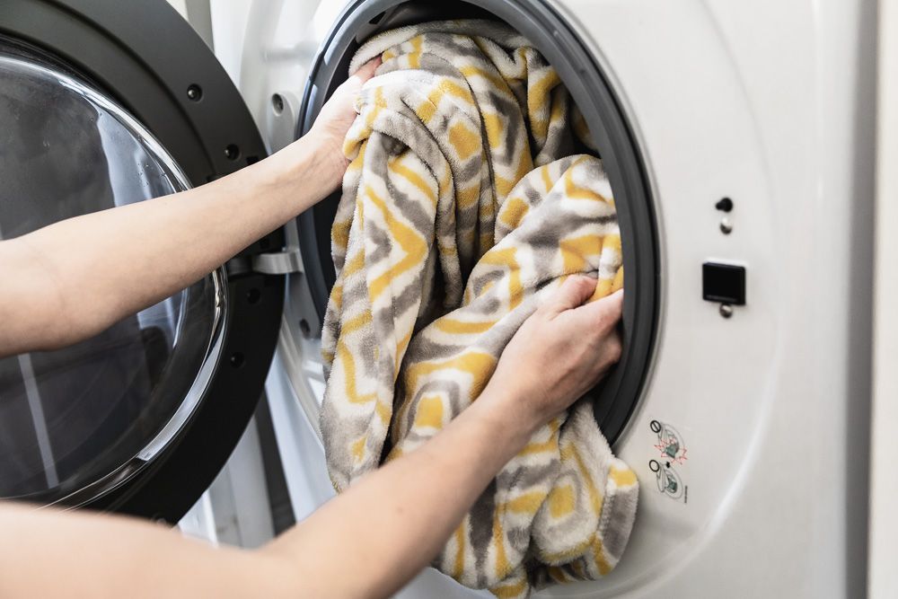 Person loading clothing into the washer