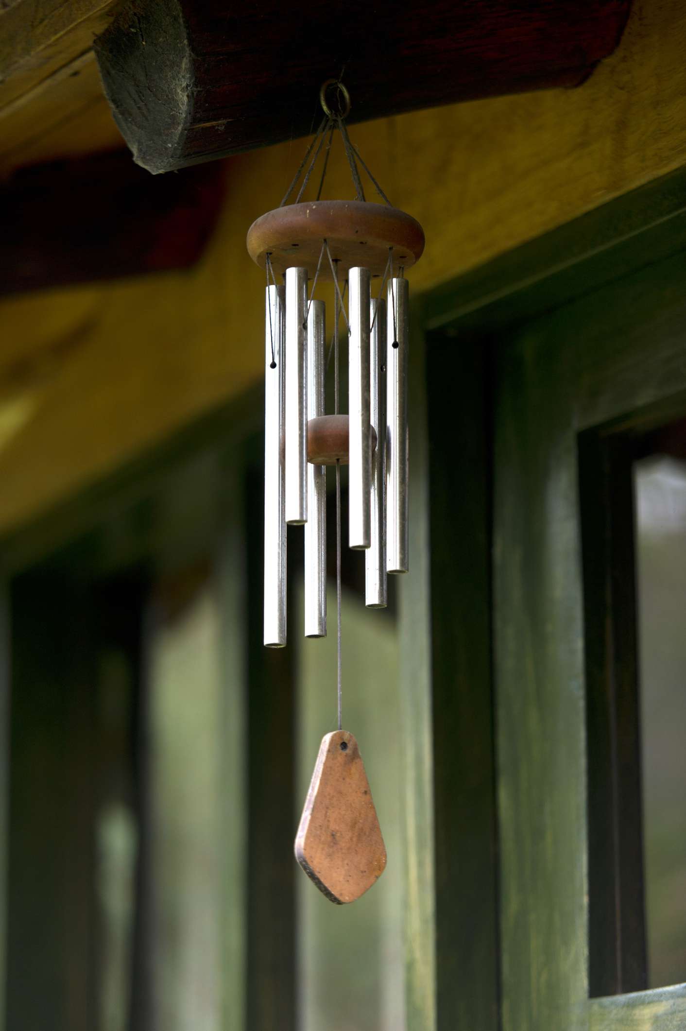 metal wind chime hanging from a roof