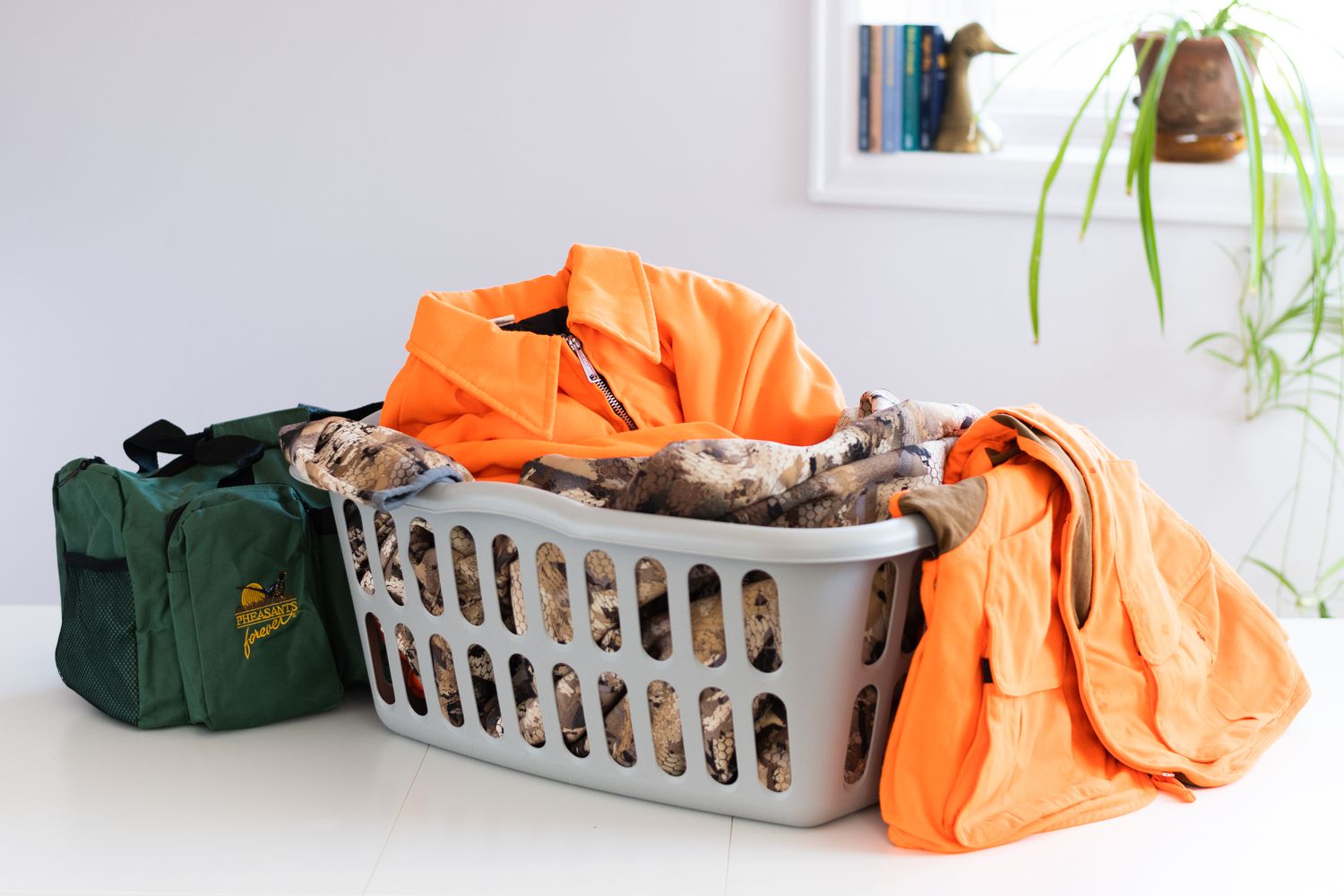 Panier à linge avec vêtements de chasse et sac de sport