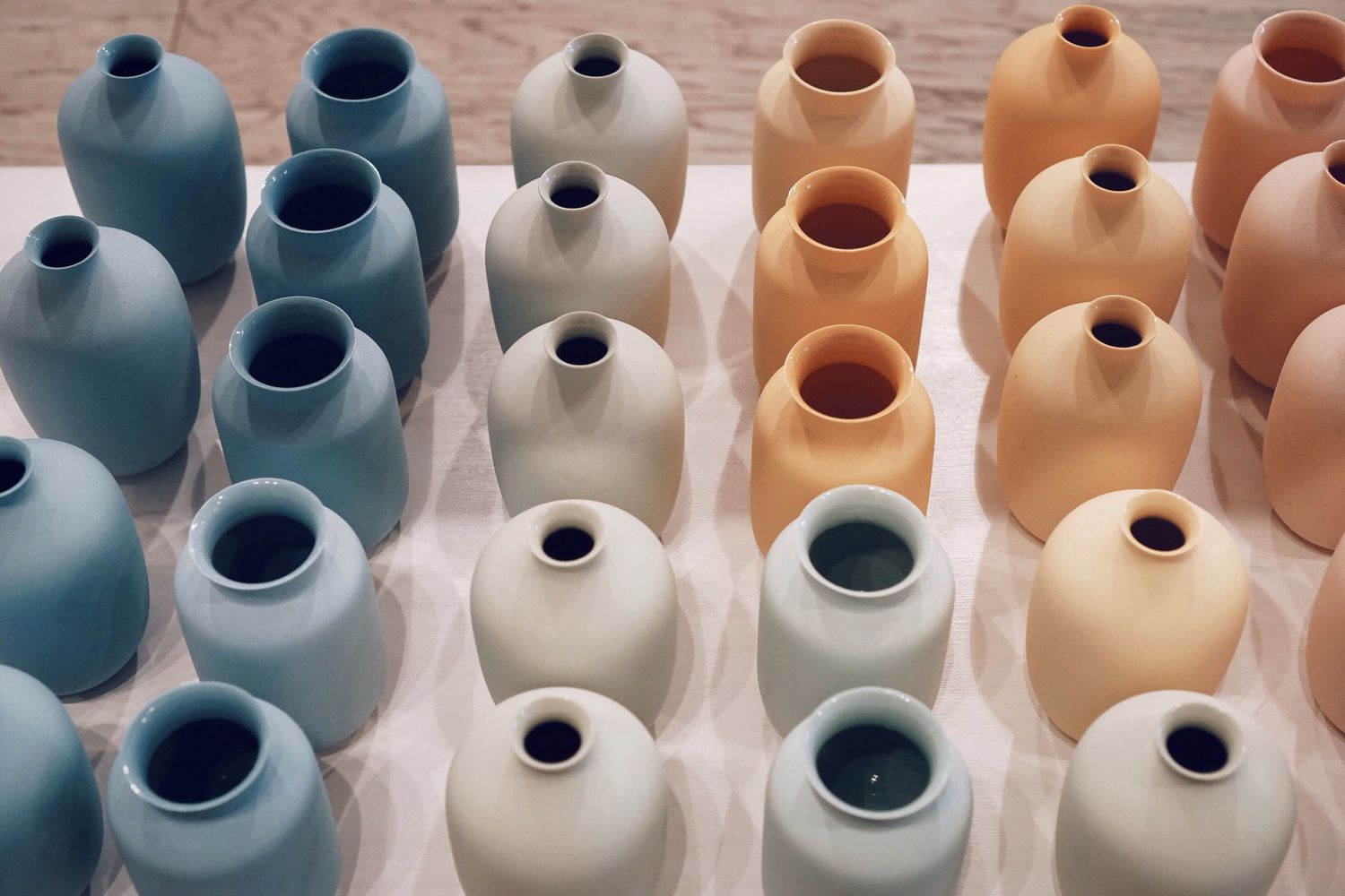 Arranjo de dezenas de vasos de cerâmica coloridos.