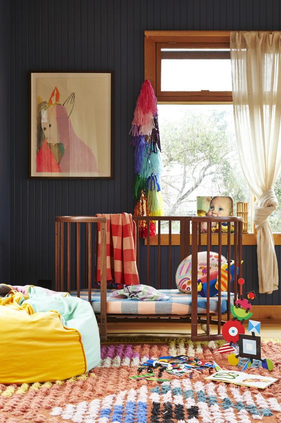 Gender-neutral nursery with black walls and bright accents