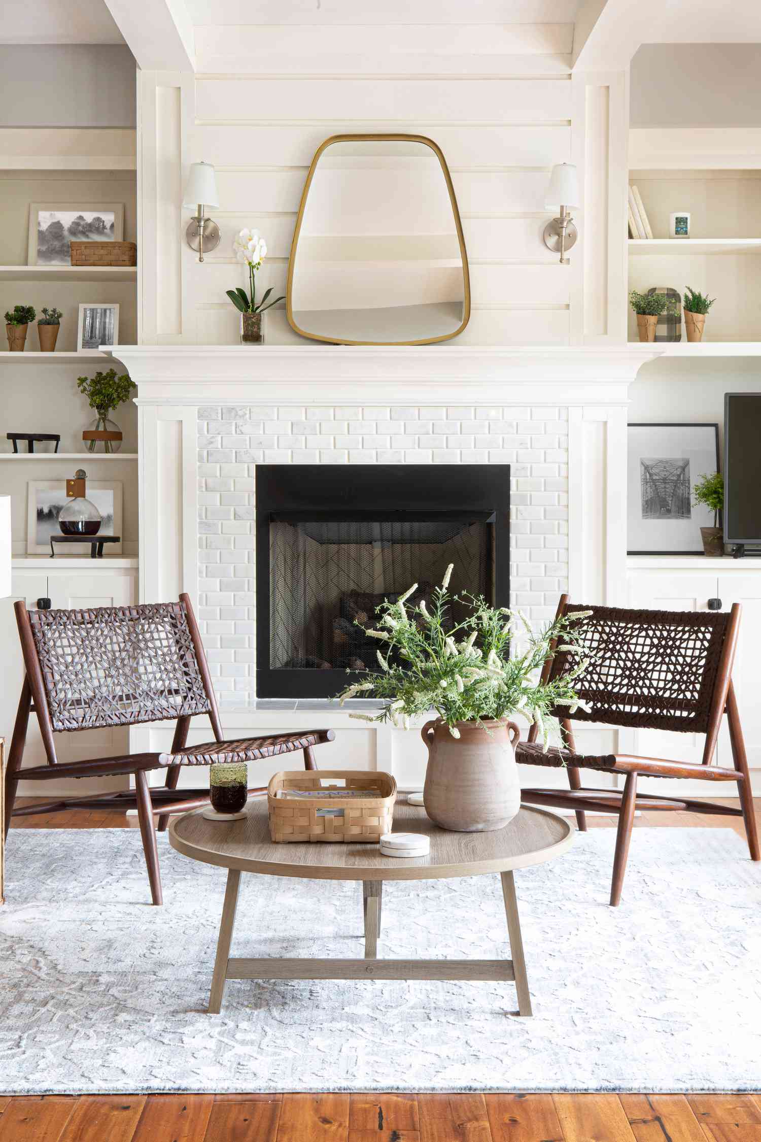 Salón blanco con chimenea, plantas y decoración minimalista