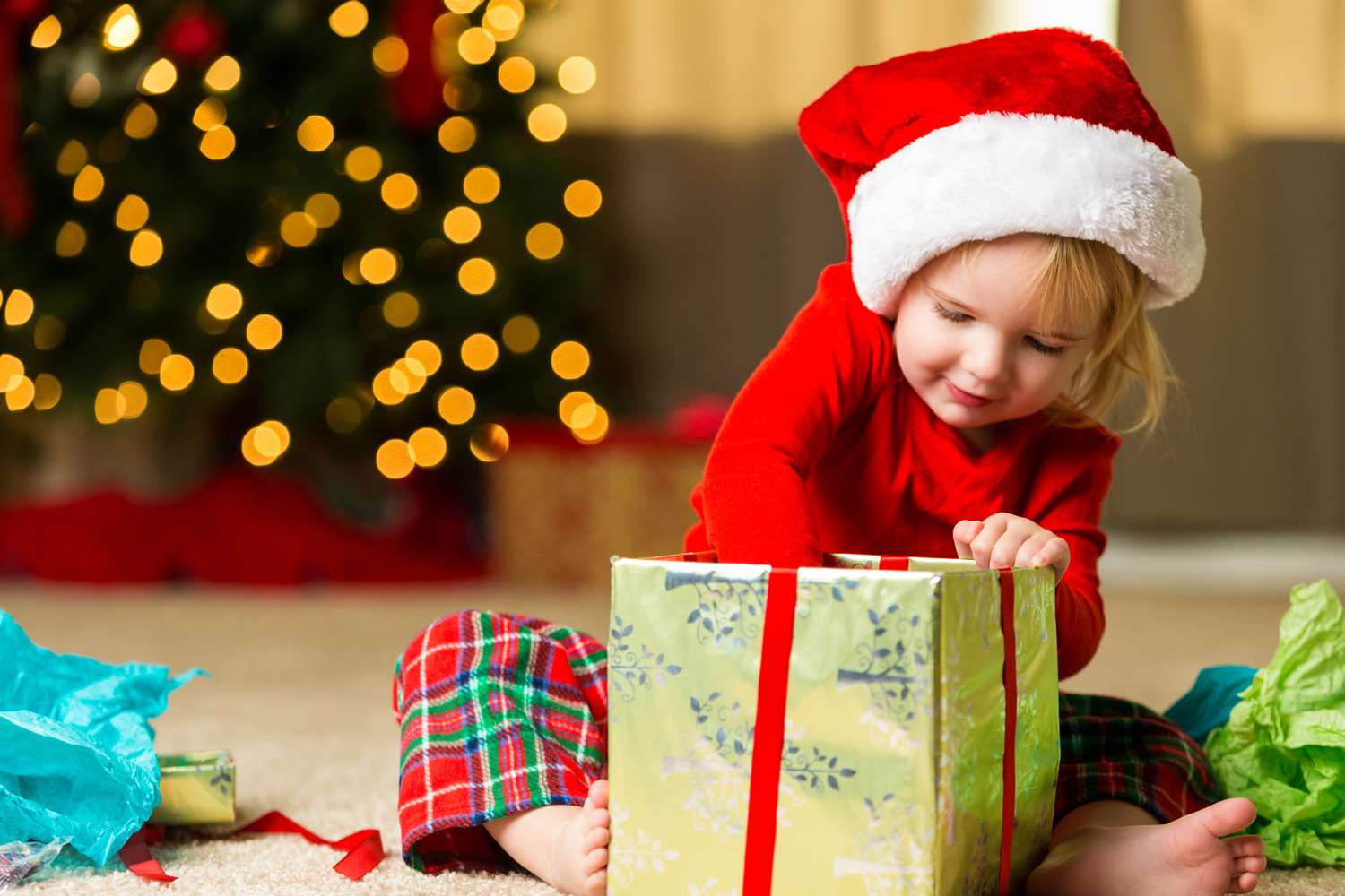 Adorável garotinha abrindo o presente de Natal