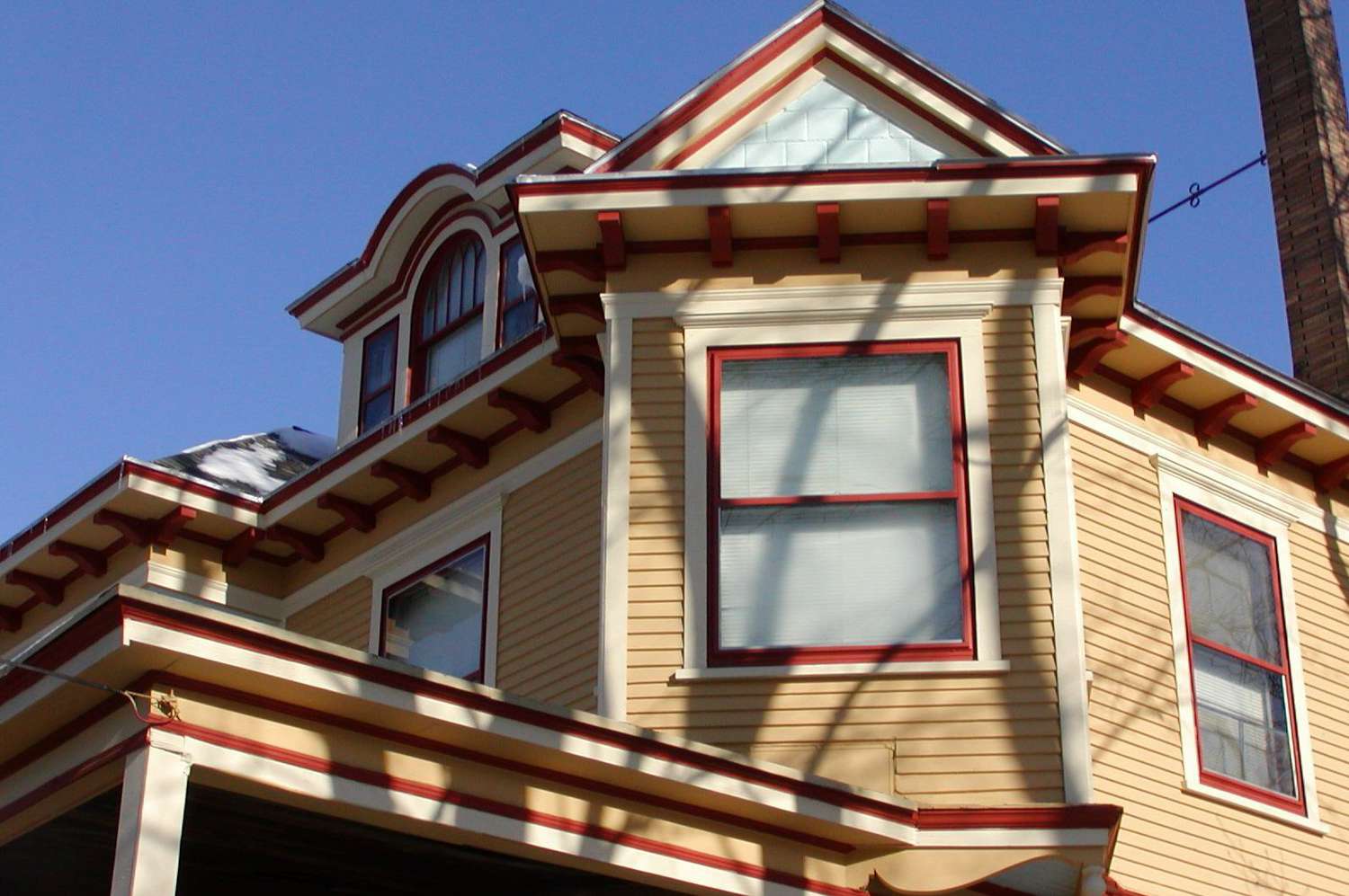 Red details dramatize a dormer painted harvest gold