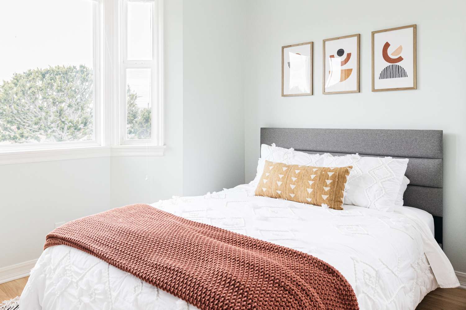 Dormitorio pequeño con paredes pintadas de color aguamarina claro con ventana luminosa