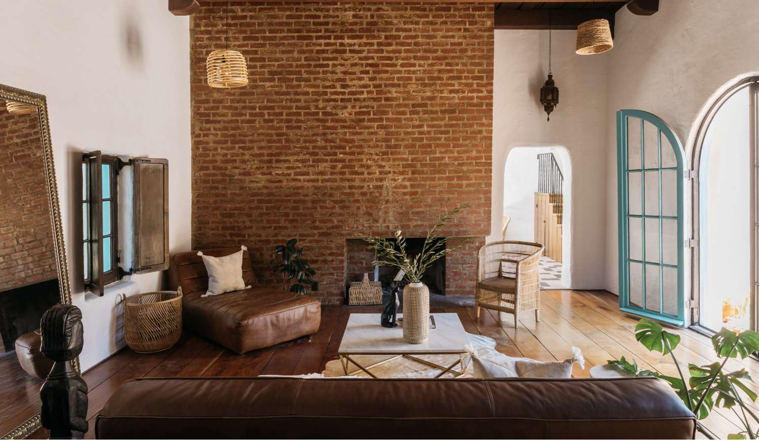 sala de estar com tijolos expostos, móveis de couro
