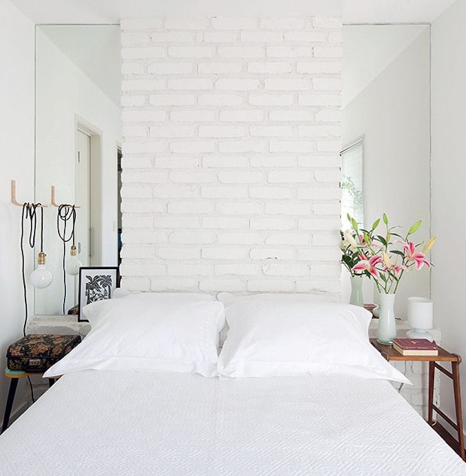 Schlafzimmer mit einem Bett vor einer Backsteinmauer