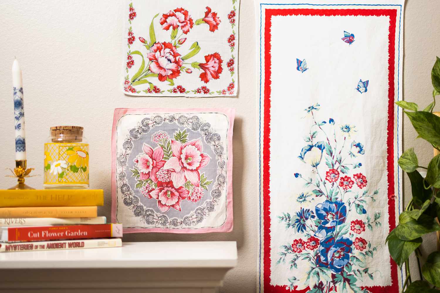 Vintage red, pink and white floral textiles hanging near shelf with books