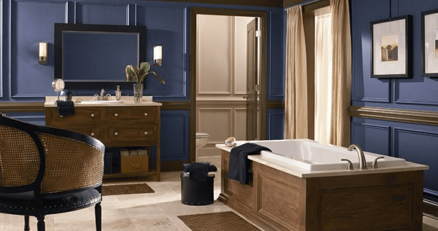 Ein riesiges, luxuriöses blaues Badezimmer mit Badewanne, Vorhängen vor dem Fenster, Waschtisch und Spiegel.