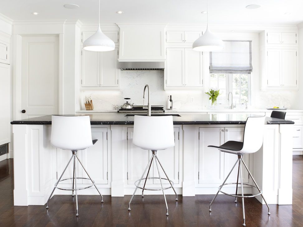 Uma cozinha com bancadas de mármore preto amaciado e um backsplash de mármore branco