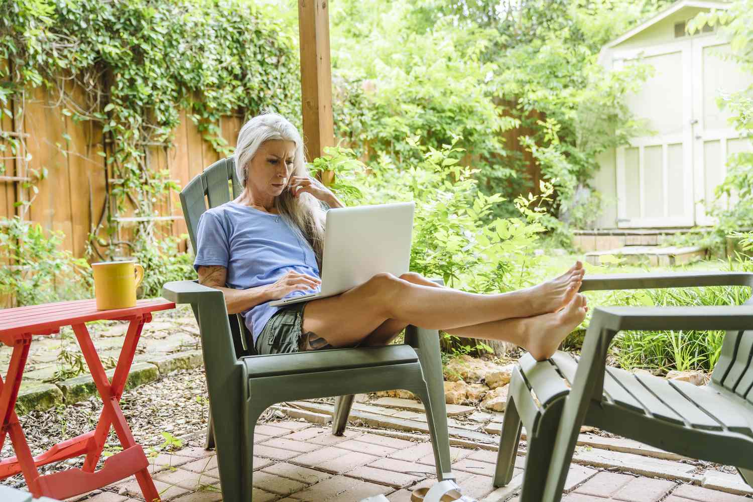 Mujer trabajando en el patio con el portátil.