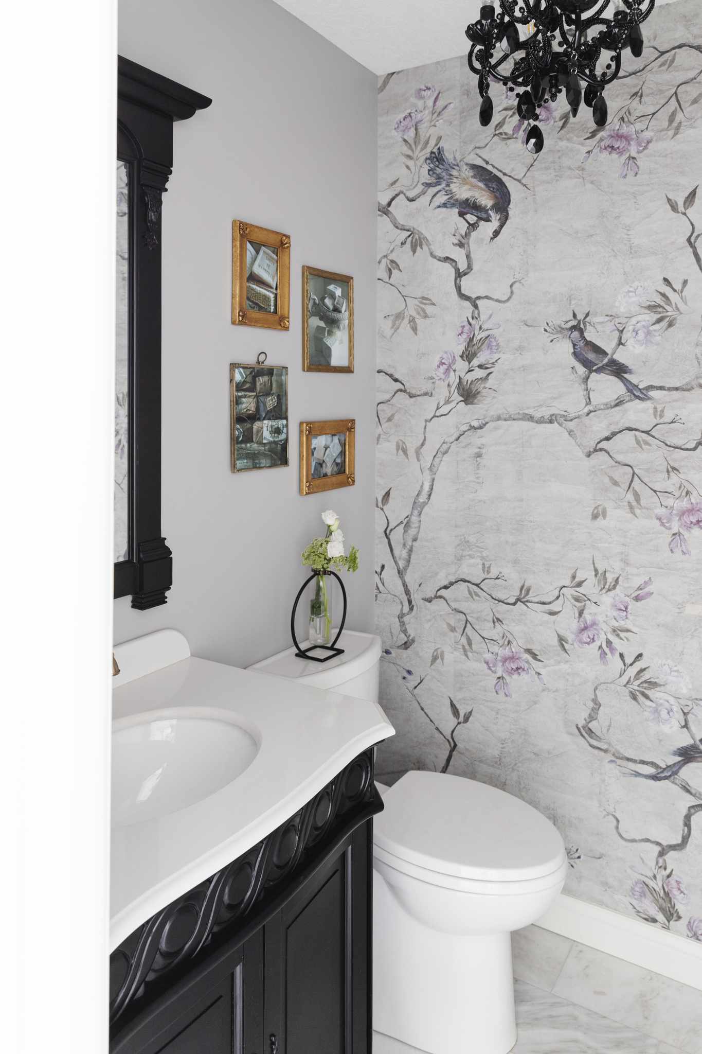 a purple and gray wallpaper mural with trees and birds used in a gorgeous powder room