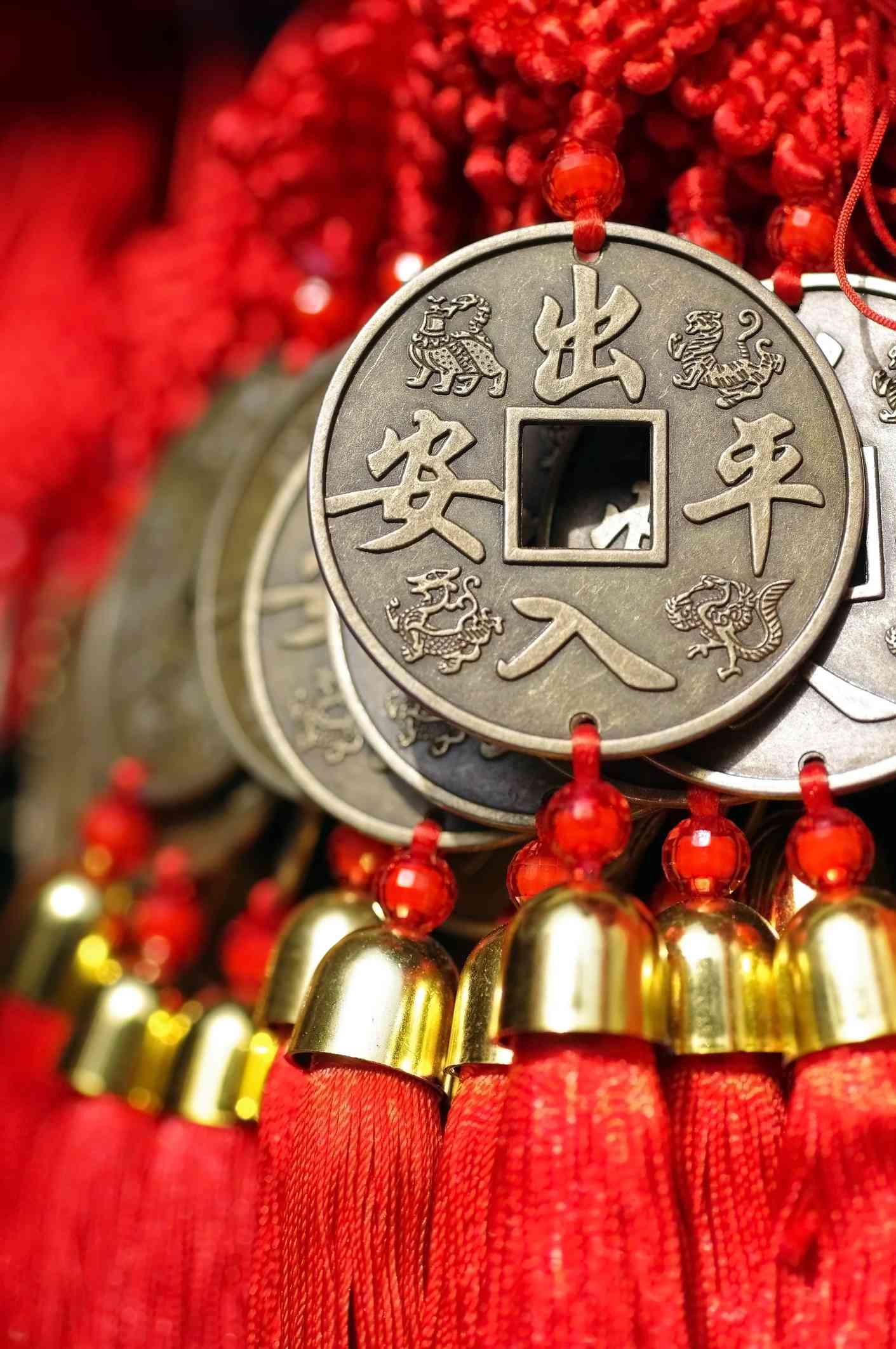 Roter chinesischer Knotenquastenschmuck, mit großen Messingmünzen.