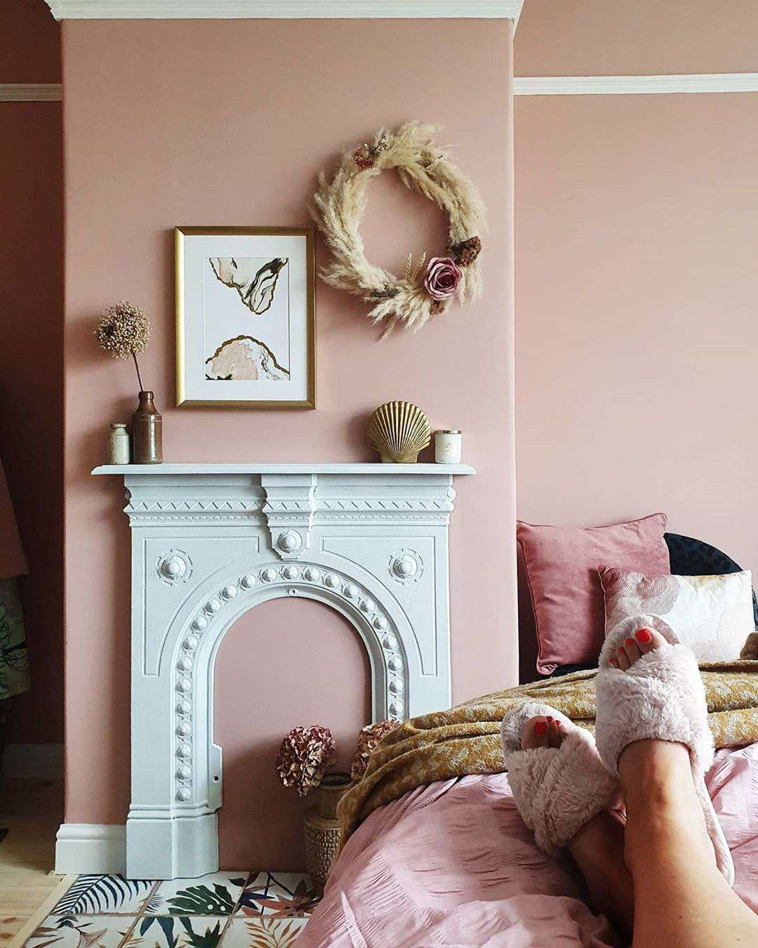 Schlafzimmer mit Kamin und hellrosa Wänden