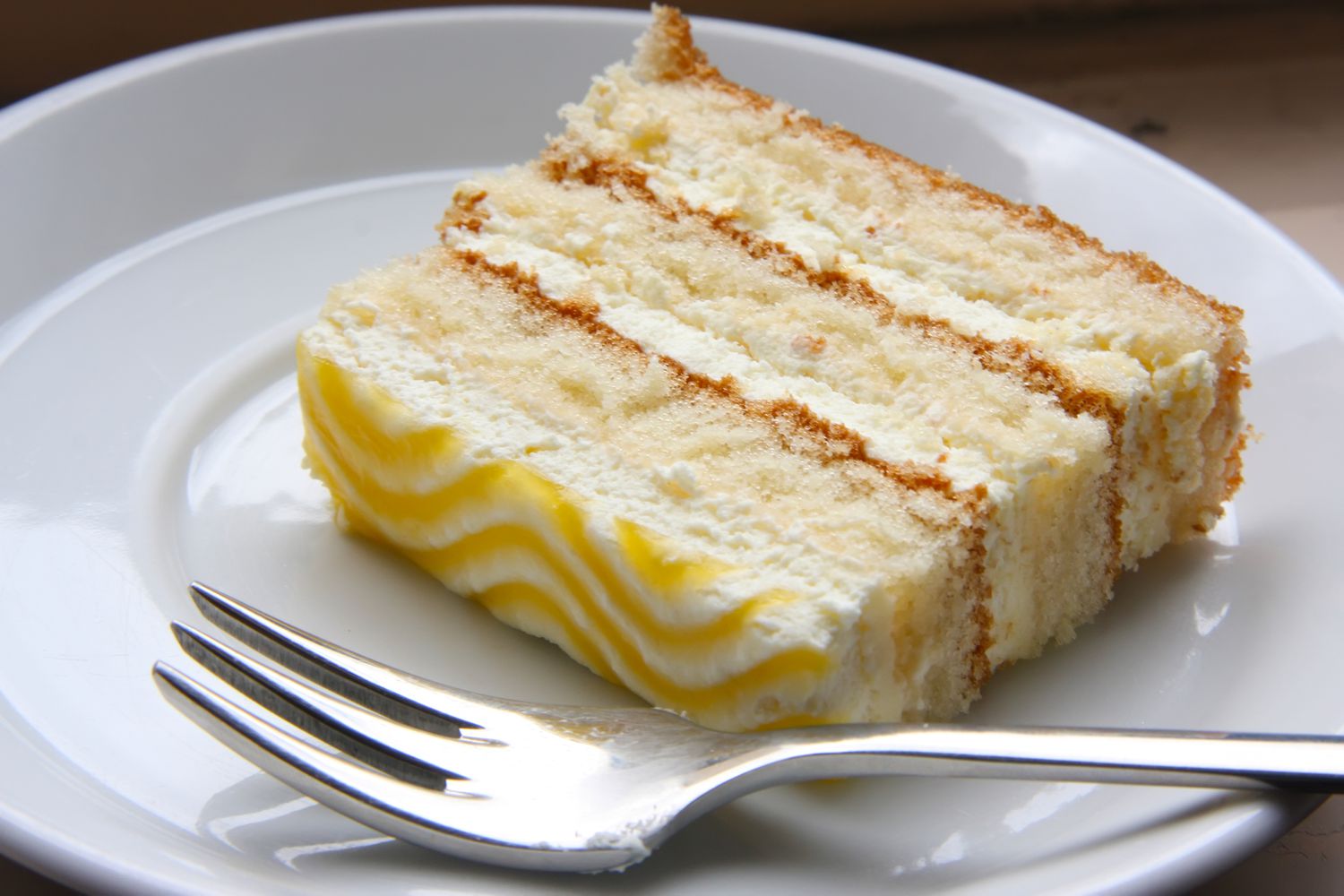 Lemon Chiffon Cake auf weißem Teller mit Gabel