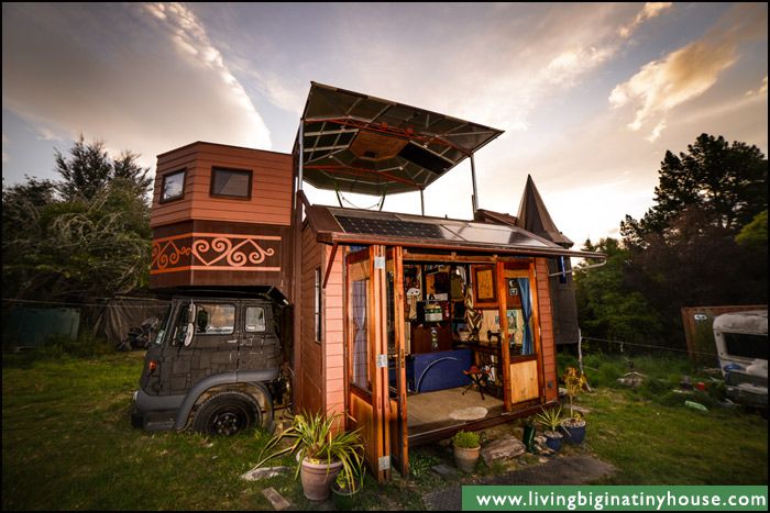 Side view of a tiny home built on a truck fashioned like a castle with doors open