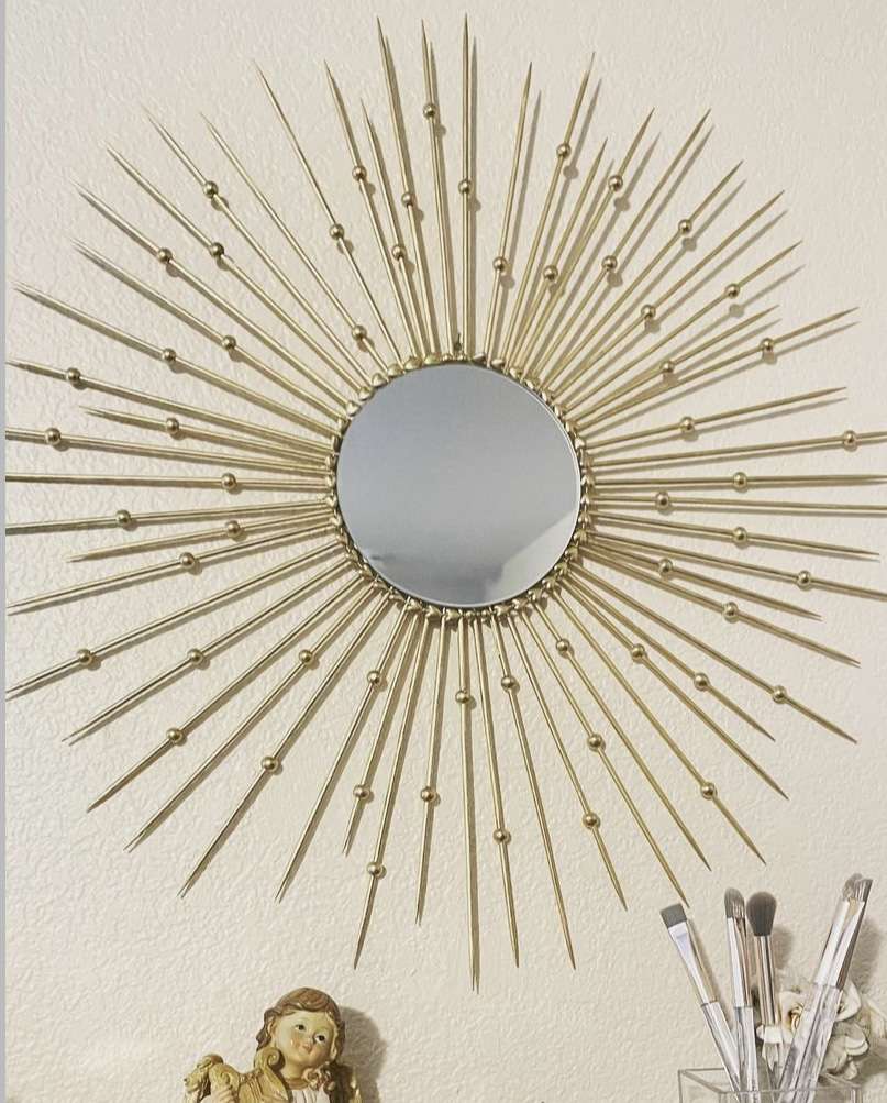 a DIY sunburst mirror frame using sticks and beads