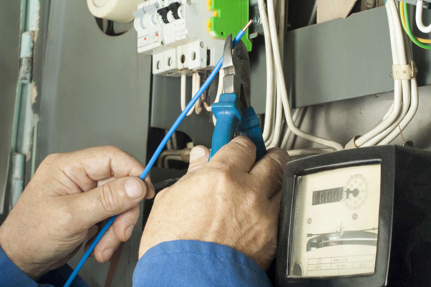 Trabajador electricista reparando fusible de distribución de línea eléctrica.