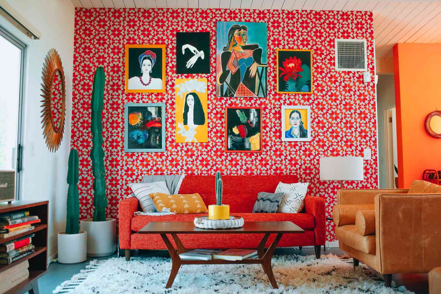 Papel de parede vermelho brilhante com obras de arte em uma sala de estar