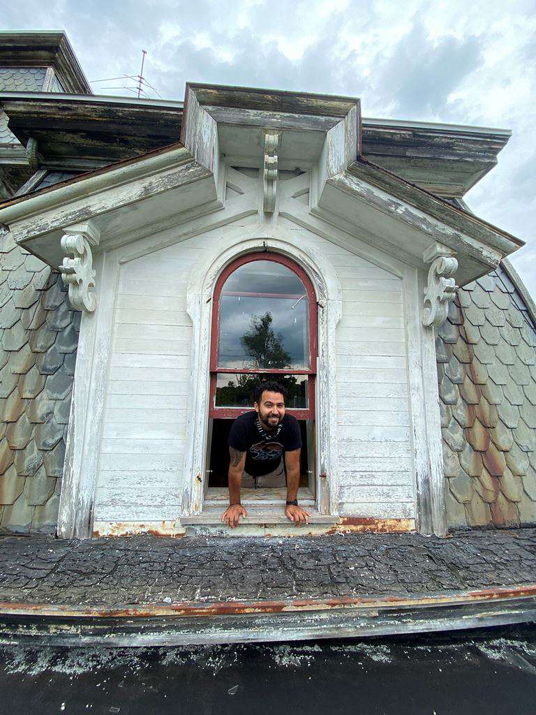 1870 historisches Haus oberes Fenster mit Mann, der sich hinauslehnt