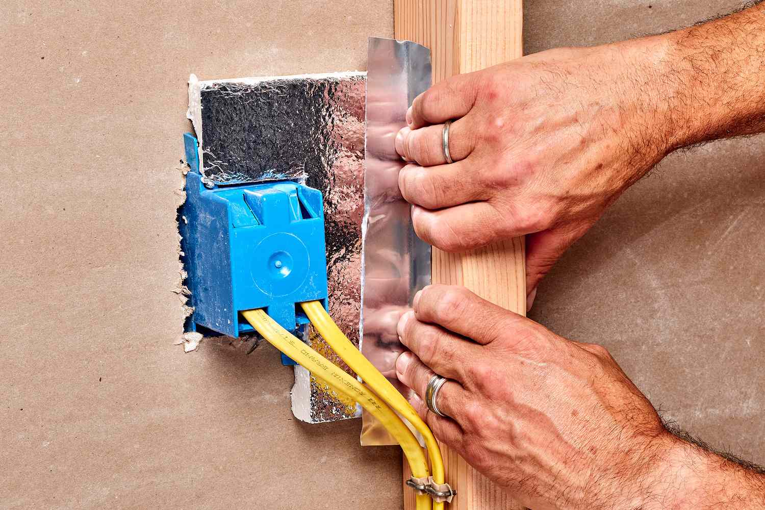 Foil keeping rigid insulation in place around electrical box