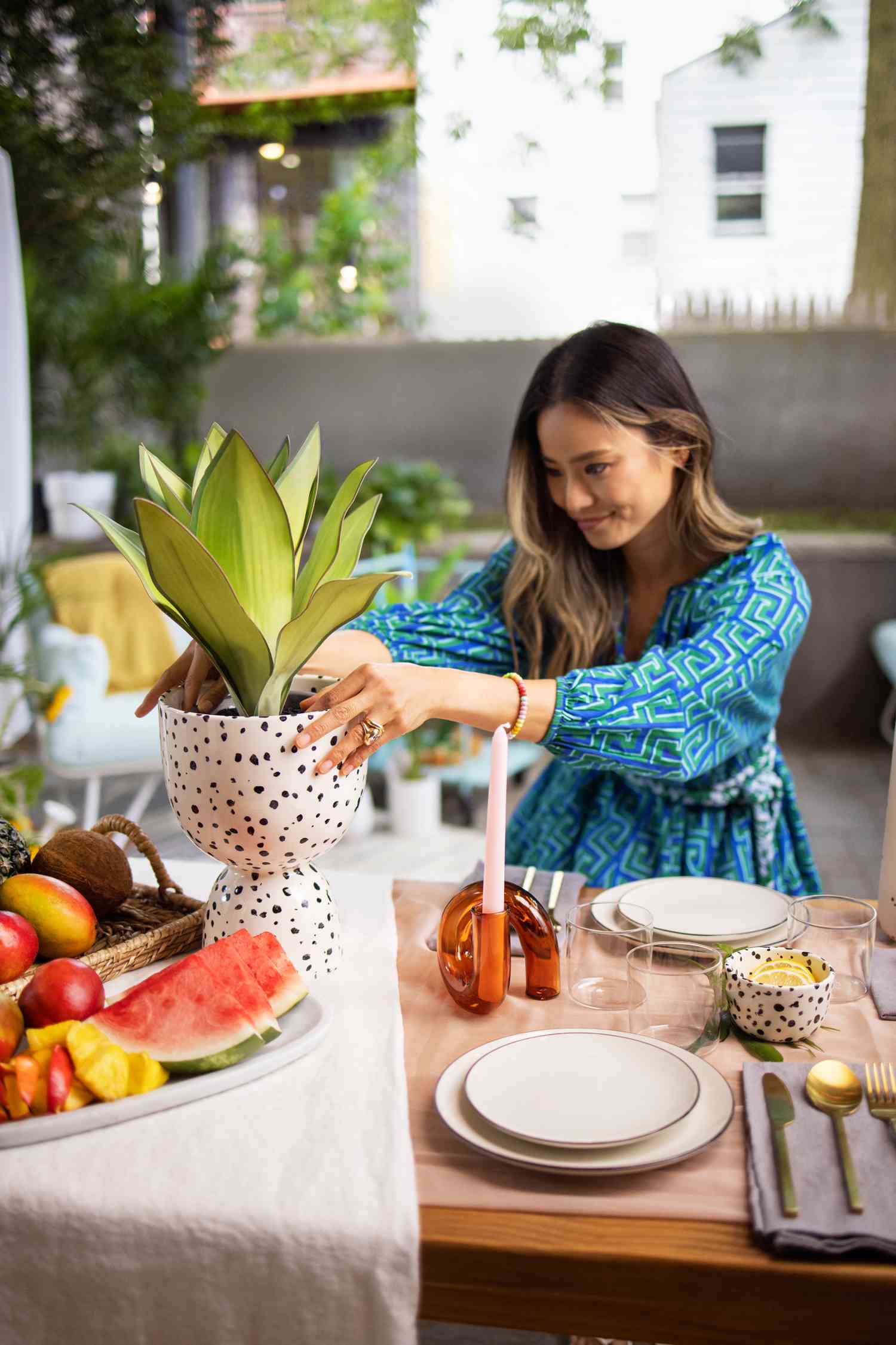 Jamie Chung arrangiert einen Blumentopf auf ihrem Esstisch im Hinterhof