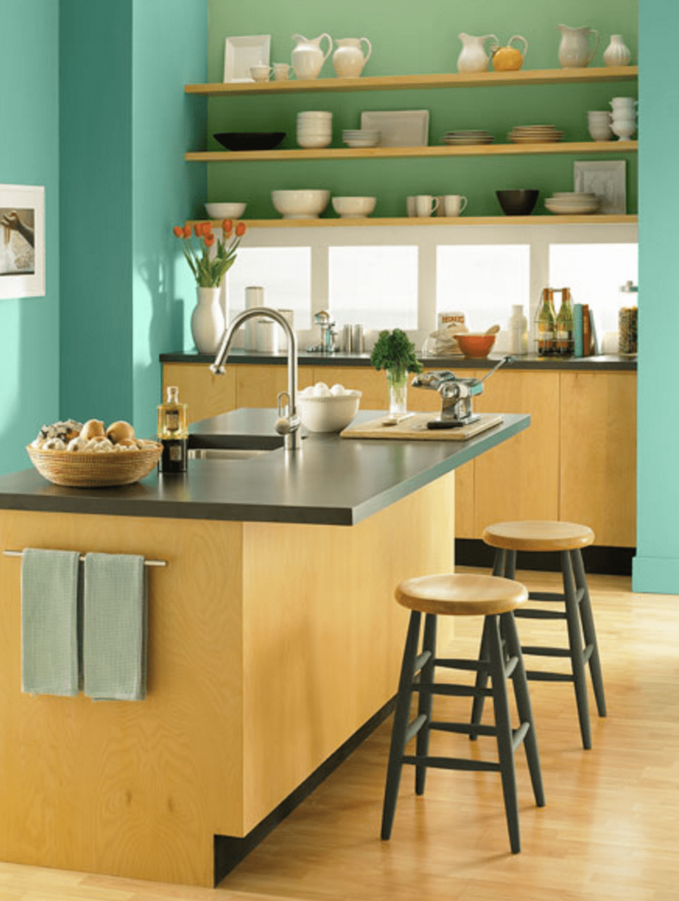 cozinha pequena com paredes azul-petróleo e armários de madeira clara
