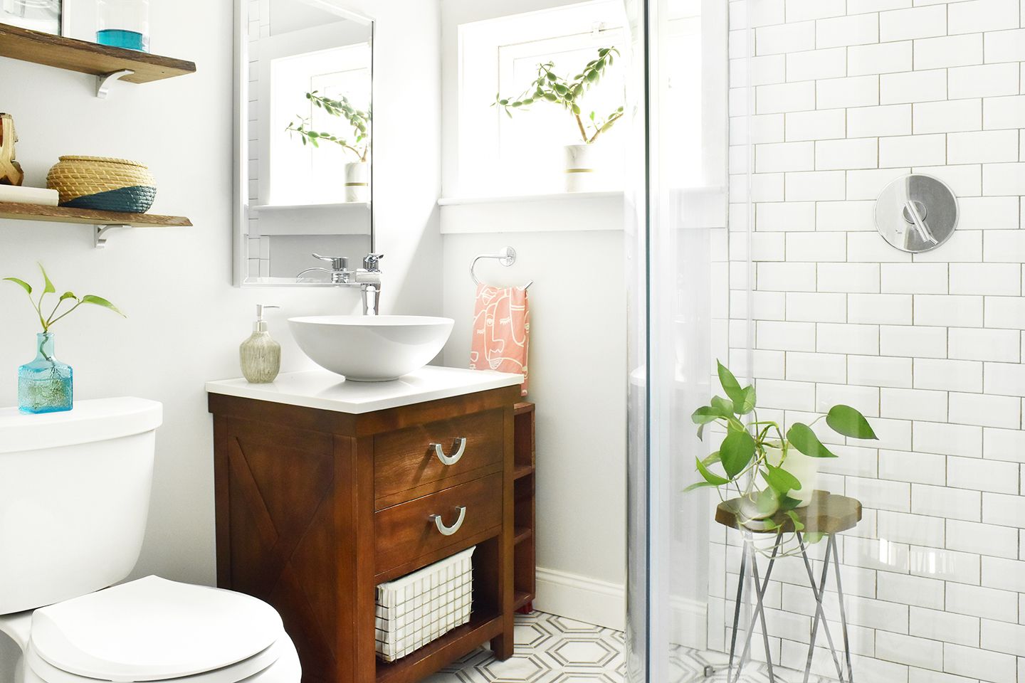 Kleines Bad mit Glasduschwand und Gefäßwaschbecken mit hellem Dekor und Zimmerpflanzen