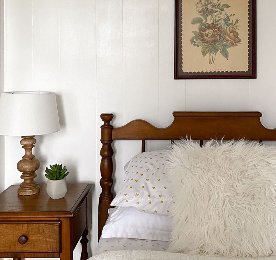 Dormitorio vintage de una adolescente con paneles blancos en las paredes y muebles de madera.