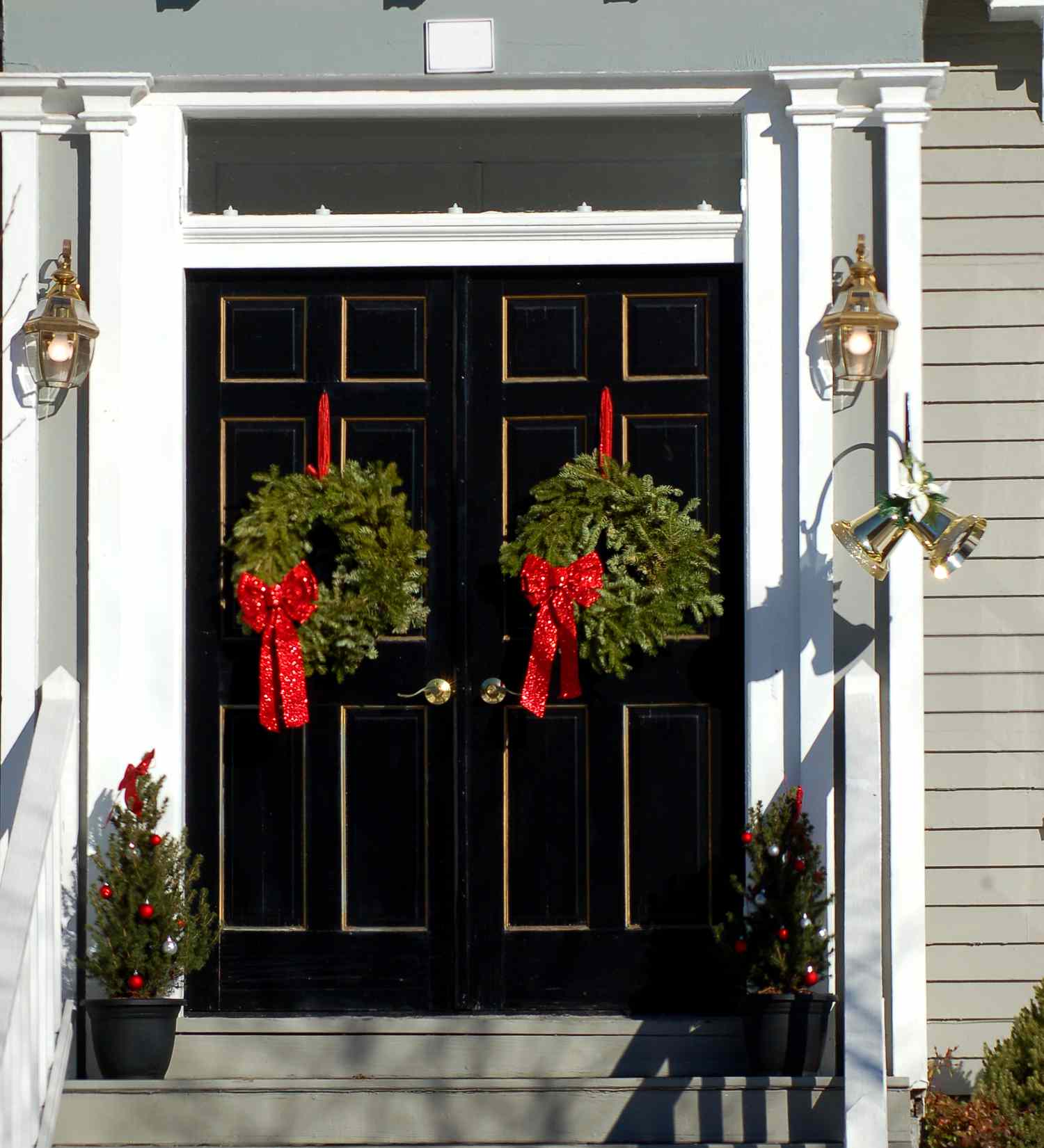 Bild: Haus mit Doppeltüren, an denen jeweils ein Weihnachtskranz hängt. Das ist eine einfache Weihnachtsdekoration.