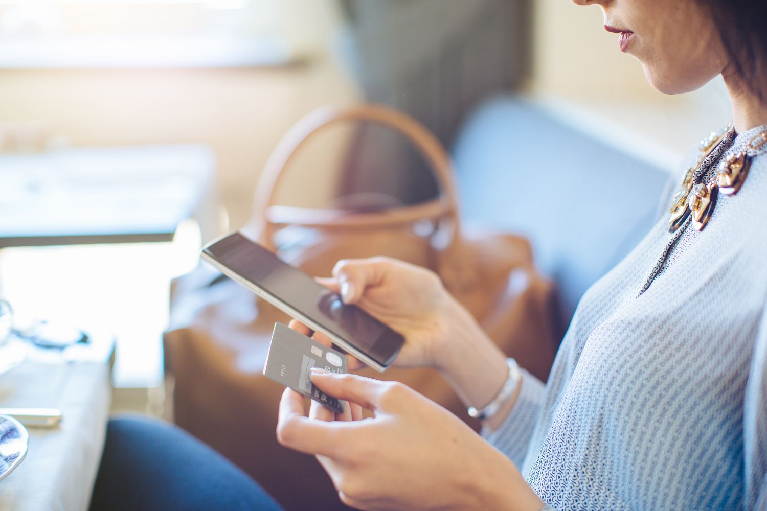 Cropped shot of young woman with digital tablet making electronic credit payment whilst having breakfast at boutique hotel in Italy