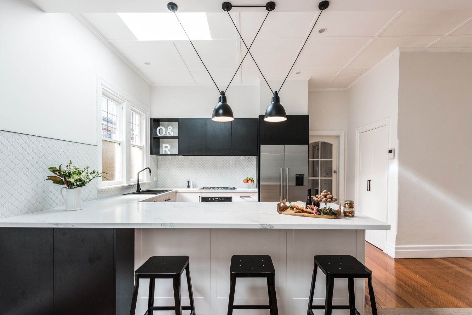 Cocina elegante y moderna en blanco y negro con suelos de madera