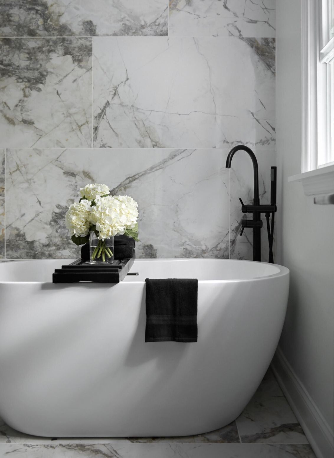 bathroom with large tile marble walls and standing bathub