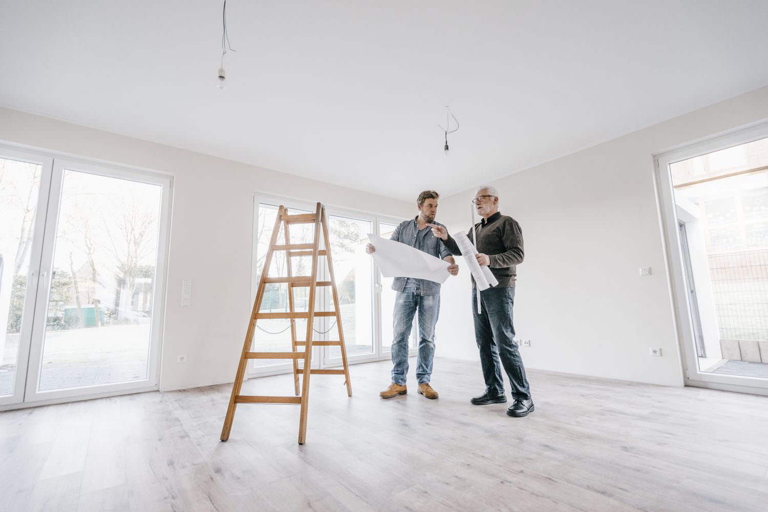 Arquitecto revisando plano de construcción con propietario de la nueva vivienda