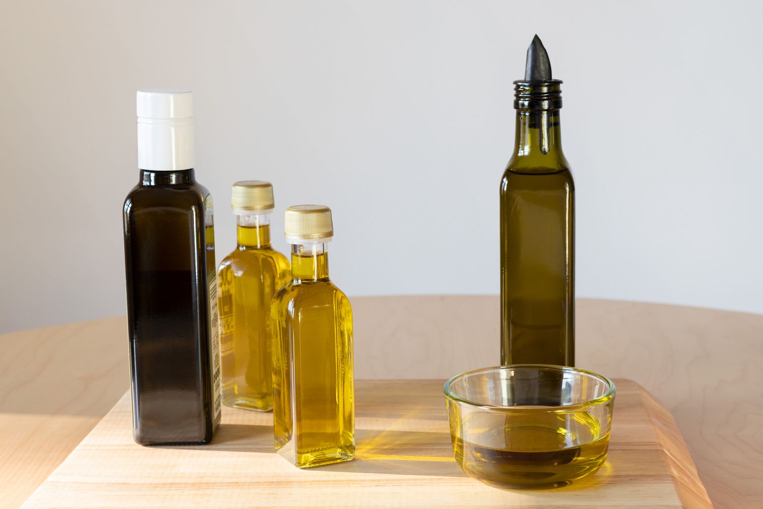 Vegetable oil in tall glass containers on wooden surface