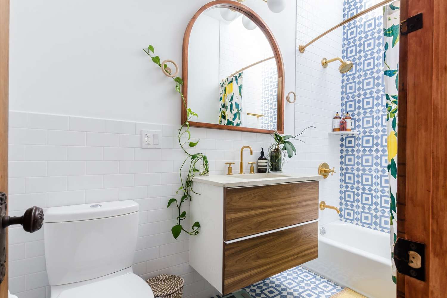 Baño diminuto con plantas de interior sobre el lavabo y ducha vista