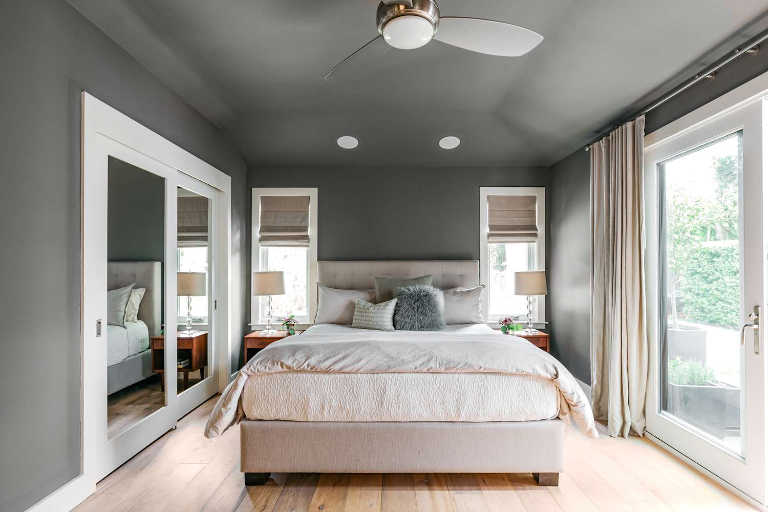 Chambre à coucher avec plafond et murs peints en gris avec lit fait au milieu