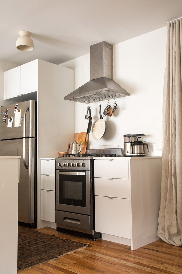 pequena cozinha branca com piso de madeira multicolorido